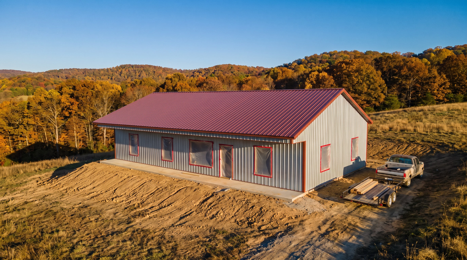 A post frame building at dry in stage with steel roof and siding on but every opening still covered and taped
